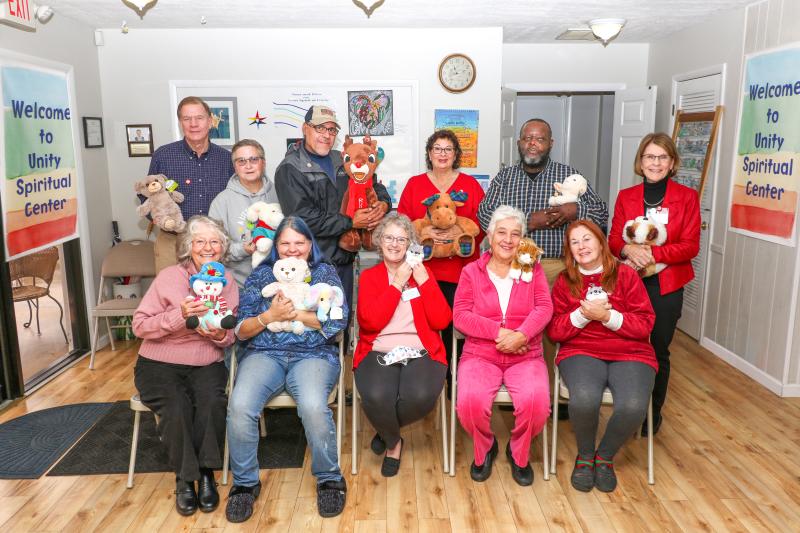 Infusing stuffed animals with hugs and love for clients at Delaware Hospice are Unity Spiritual Center of Coastal Delaware members in back (l-r) John Dickman, Loretta Fisher, Luis Hernandez, Donna Tenaglia, Leroy White and Kathy Dickman. In front are the Rev. Karen Laughman; April Morehouse; Susan Beckham, program organizer; Pat Leef; and Jeanne Blake. SUBMITTED PHOTO